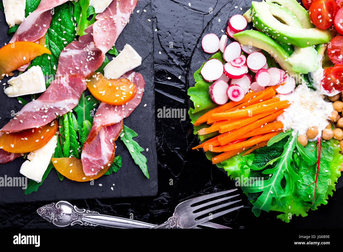 Two different salads om black stone slate. Vegan salad. Meat salad