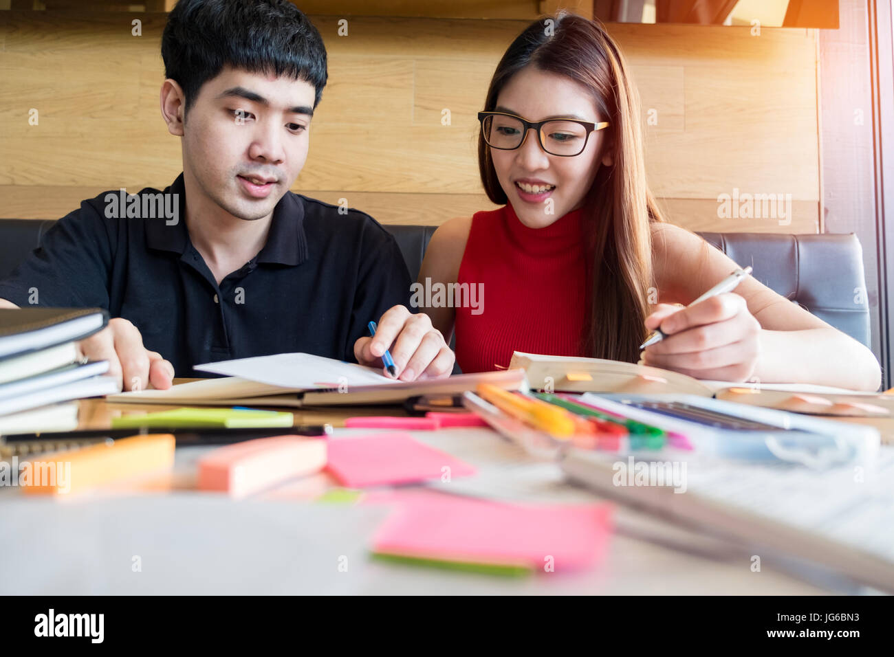 A teenage girl and boy doing their homework together. Stock Photo