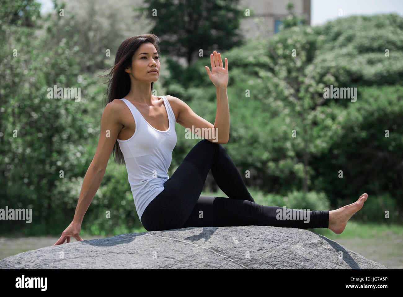 A beautiful young asian woman stretching, exercising and doing yoga outdoor in a park Stock Photo