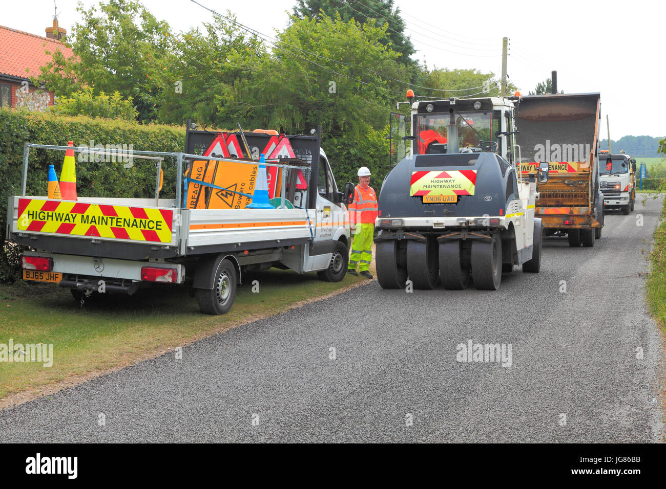 Road Surface, Dressing, Repair, trucks, Norfolk, England, UK, bitumen emulsion, stone chippings Stock Photo