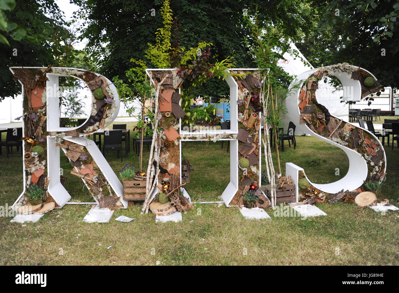 A rustic Royal Horticultural Society logo on display on display at the 2017 RHS Hampton Court Flower Show which opened today in the grounds of Hampton Court Palace, London, United Kingdom.  The RHS Hampton Court Palace Flower Show is the world’s largest flower show boasting an eclectic mix of gardens, displays and shopping opportunities spanning over 34 acres either side of the dramatic long water with the stunning façade of the historical palace in the background. Around 130,000 people attend the show each year.  The show was first held in 1990 and created by Historic Royal Palaces and Networ Stock Photo