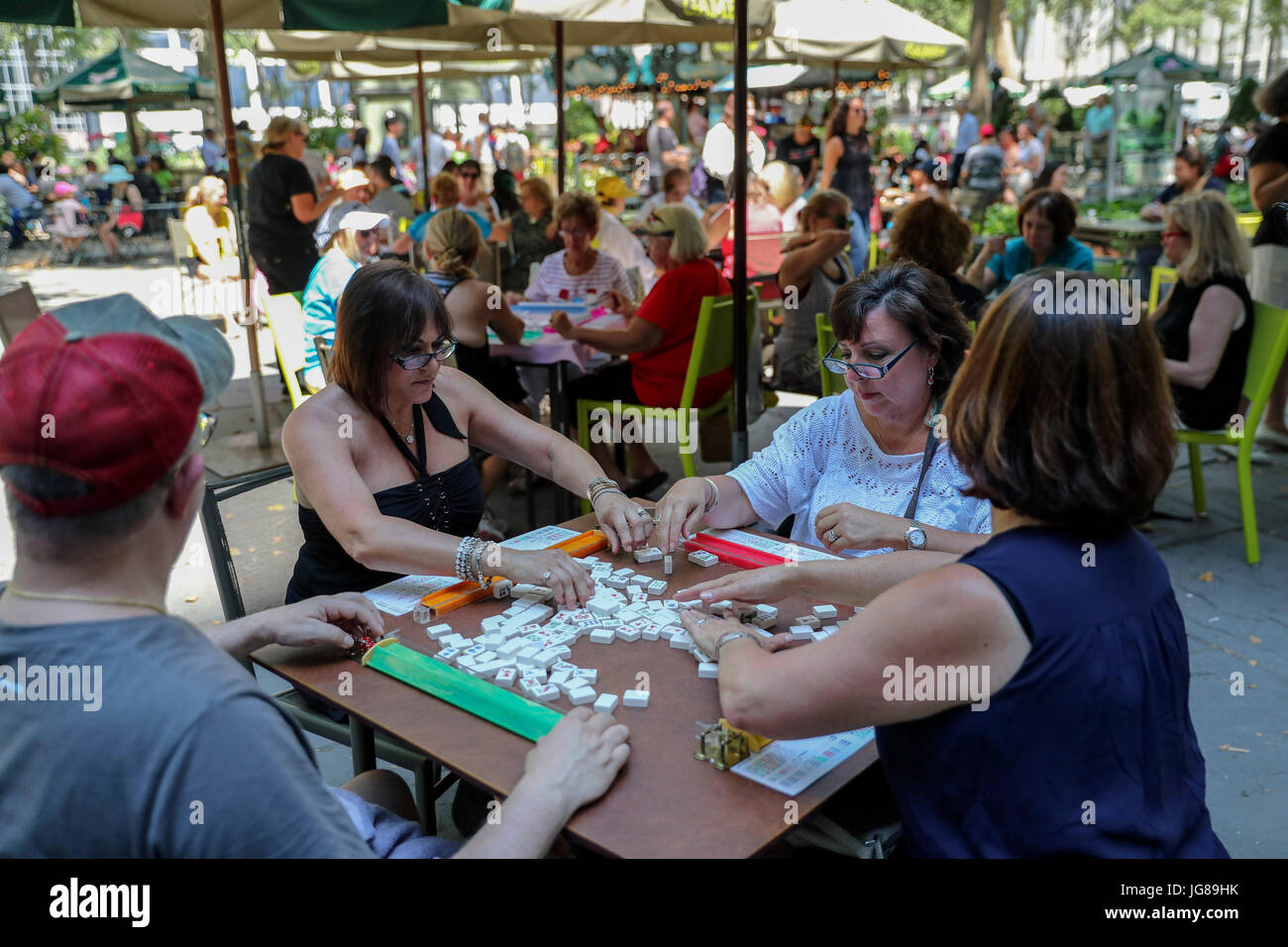New York, USA. 3rd July, 2017. Hobbyists play Mah Jongg during the 'Mah Jongg Marathon' event at Bryant Park in New York City, the United States, on July 3, 2017. According to event organizer Linda Fisher, the event is organized to provide a place for Mah Jongg hobbyists to communicate with each other and promote the game to more people. Mah Jongg, originated from China, was introduced to the United States in the 1920s. Credit: Wang Ying/Xinhua/Alamy Live News Stock Photo