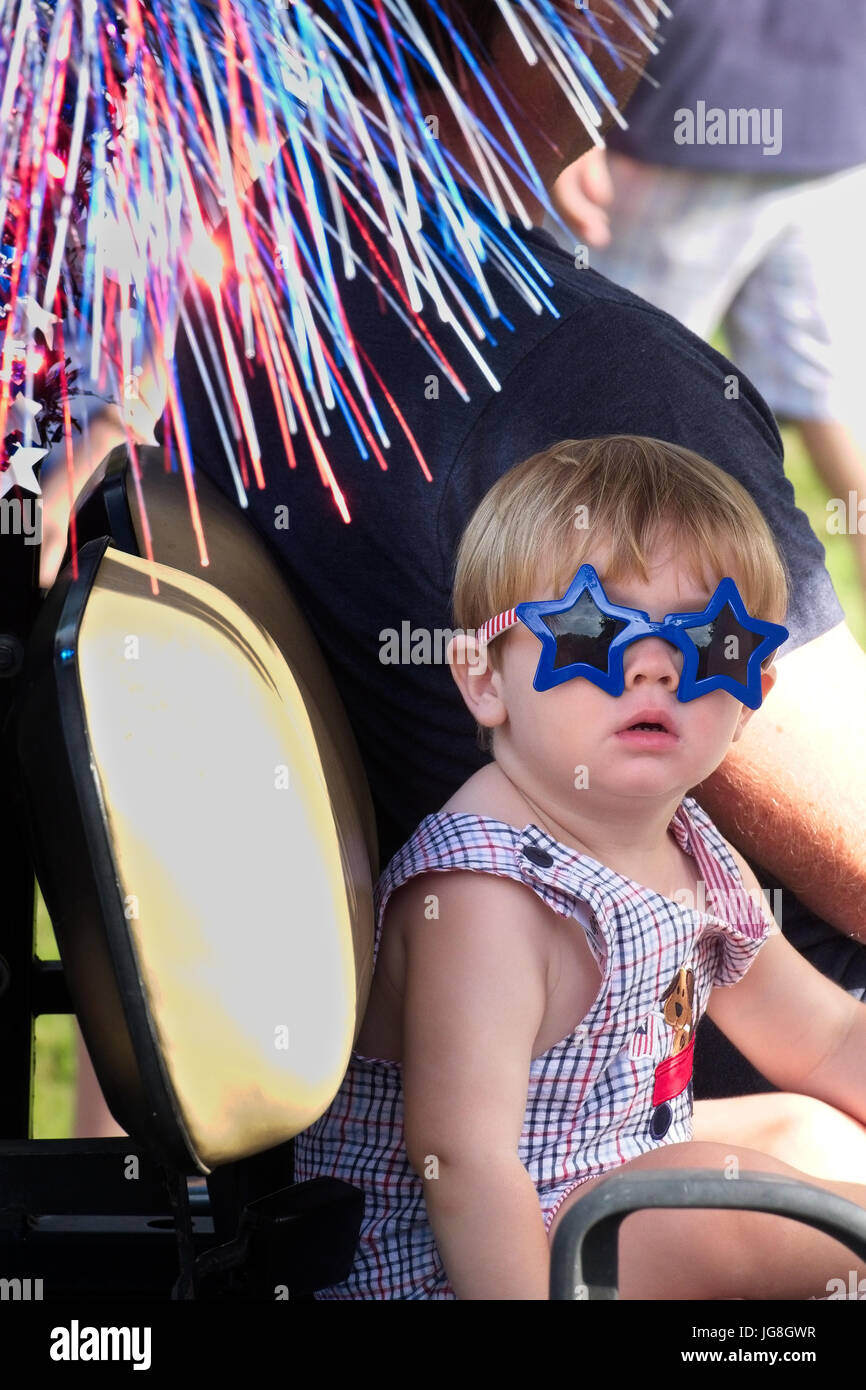 Sullivan's Island, South Carolina, USA. 4th July, 2017. A young child wears stars and stripes sunglasses during the annual Sullivan's Island Independence Day parade July 4, 2017 in Sullivan's Island, South Carolina. The tiny affluent sea island hosts a bicycle and golf cart parade through the historic village. Credit: Planetpix/Alamy Live News Stock Photo