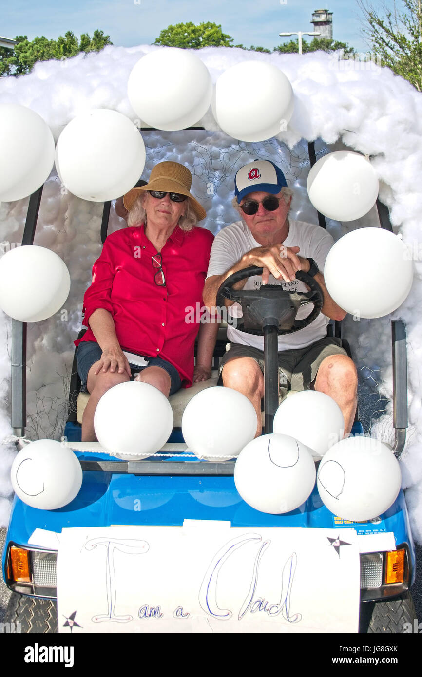 Sullivan's Island, South Carolina, USA. 4th July, 2017. An elderly couple poses inside their cloud decorated golf cart during the annual Sullivan's Island Independence Day parade July 4, 2017 in Sullivan's Island, South Carolina. The tiny affluent sea island hosts a bicycle and golf cart parade through the historic village. Credit: Planetpix/Alamy Live News Stock Photo