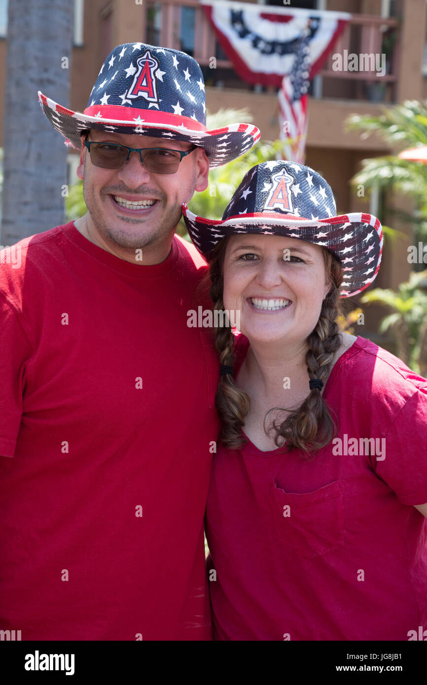 Long Beach, USA. 04th July, 2017. Portrait of a couple wearing red shirts and  red, white and blue Los Angeles Angels of Anaheim cowboy hats at the Bluff Heights 4th of July Block Party, Long Beach, CA Credit: Kayte Deioma/Alamy Live News Stock Photo