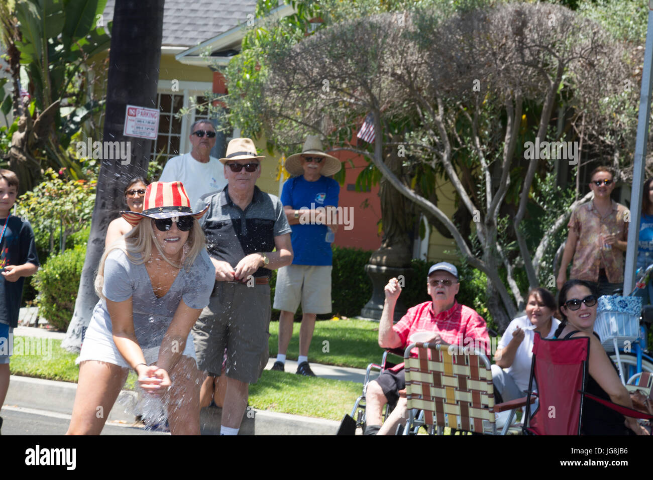 Long Beach, USA. 04th July, 2017. A woman in a red, white and blue cowboy hat catches a water balloon at the Bluff Heights 4th of July Block Party, Long Beach, CA Credit: Kayte Deioma/Alamy Live News Stock Photo