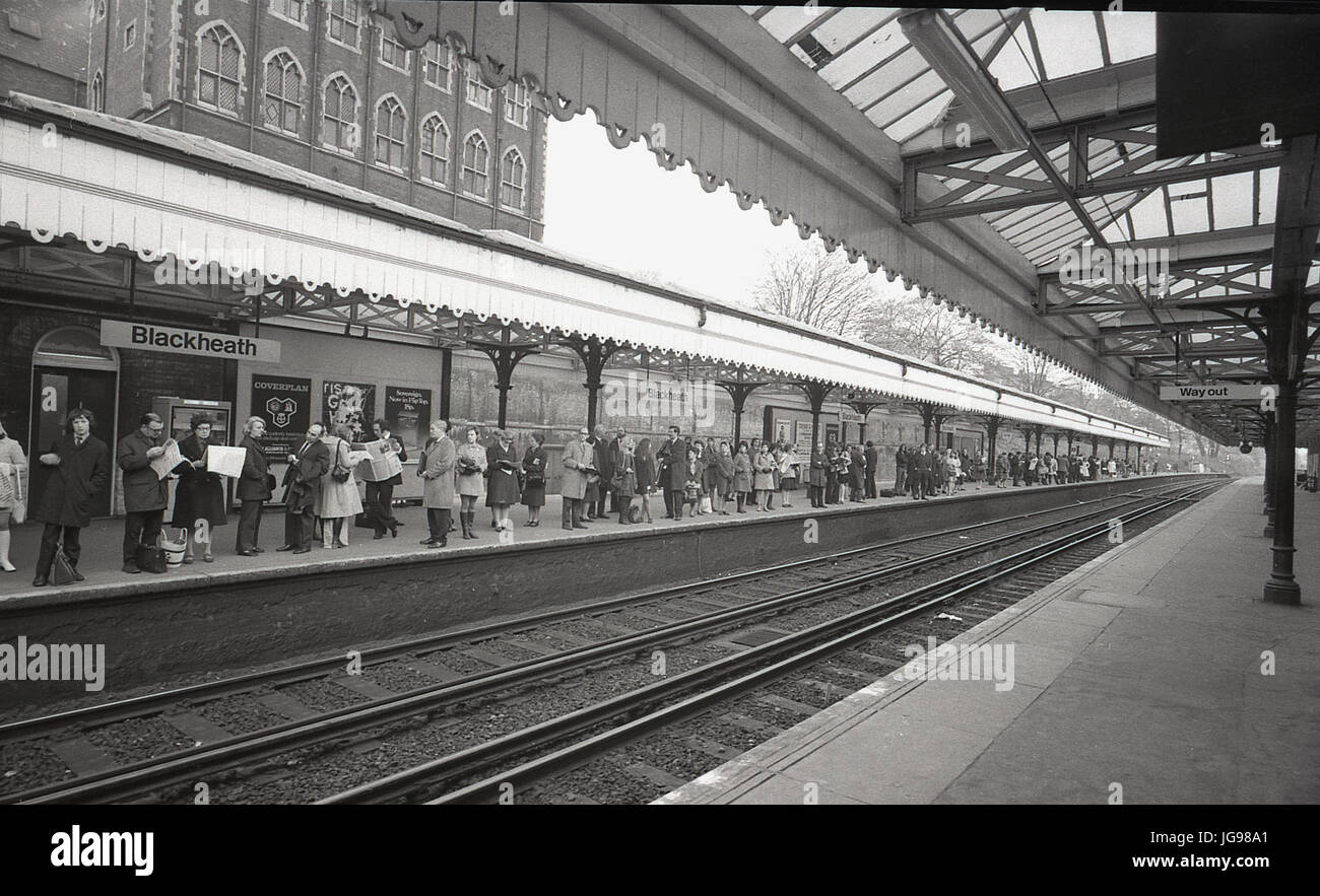 1970s, historical, passengers waiting under weather canopies for the arrival of a train to London at Blackheath railway station, Blackheath, London, England, UK. At this time, delays and cancellations were common due to industrial action and strikes by the rail unions. Stock Photo