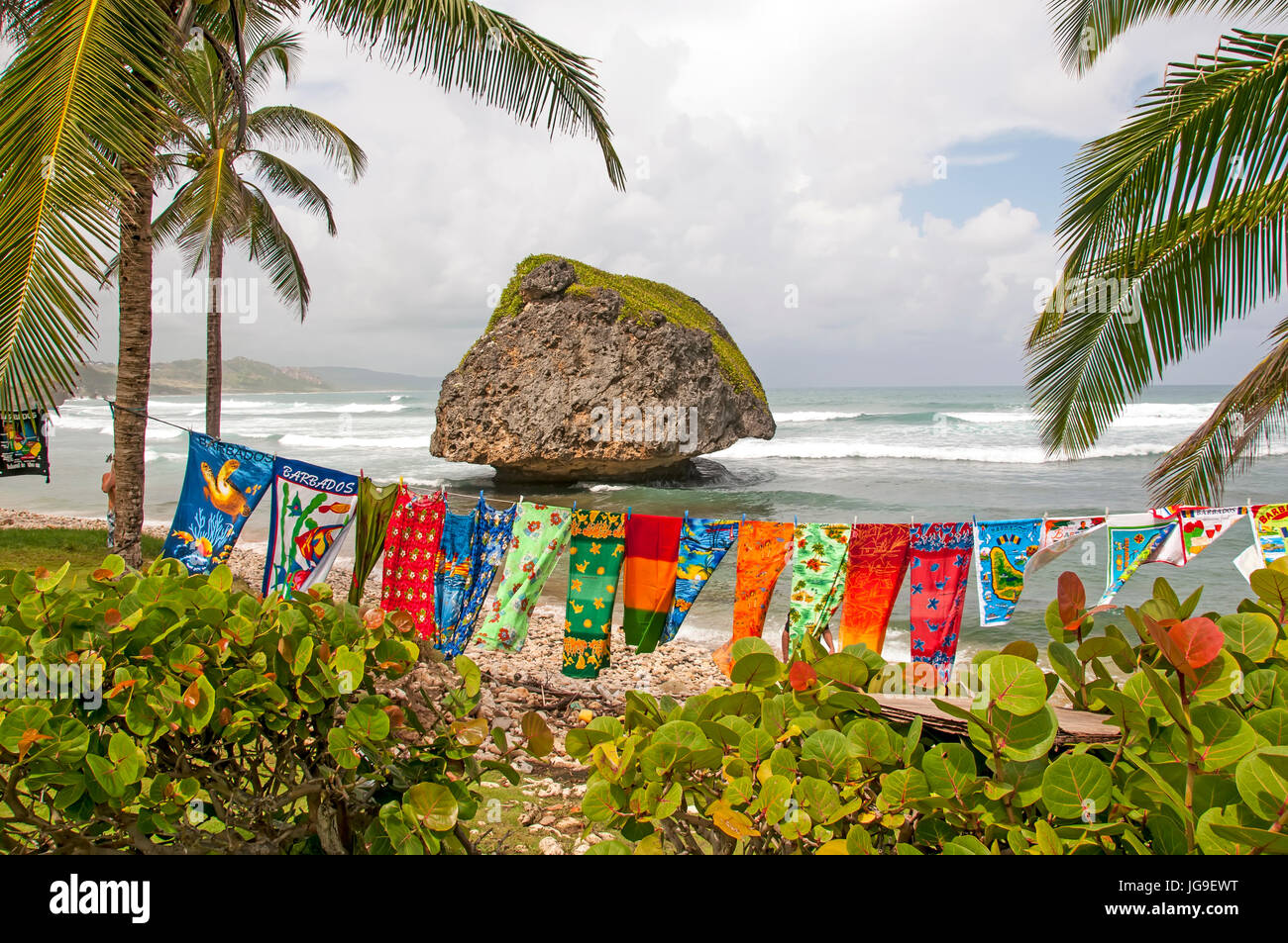 Bathsheba Barbados dramatic boulder on deserted beach with colorful clothes on clothesline blowing in wind. Stock Photo