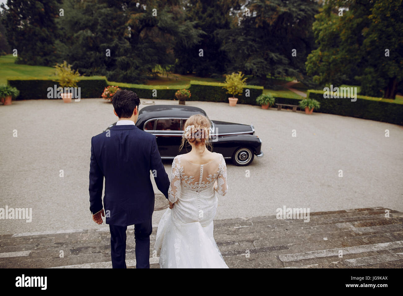 bride and groom standing in the yard near the car Stock Photo - Alamy