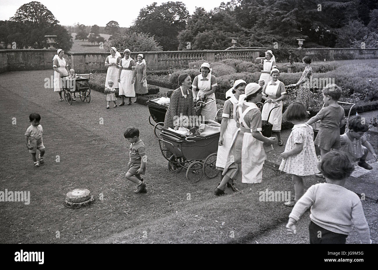 1940, England, wartime, nurses with childern In the grounds of Stanstead Hall, home of Lady Butler (Sydney Courtauld) wife of Rab Butler, Conservative politician, the nurses were there to look after the child evacuees from London who had left during the blitz. Stock Photo