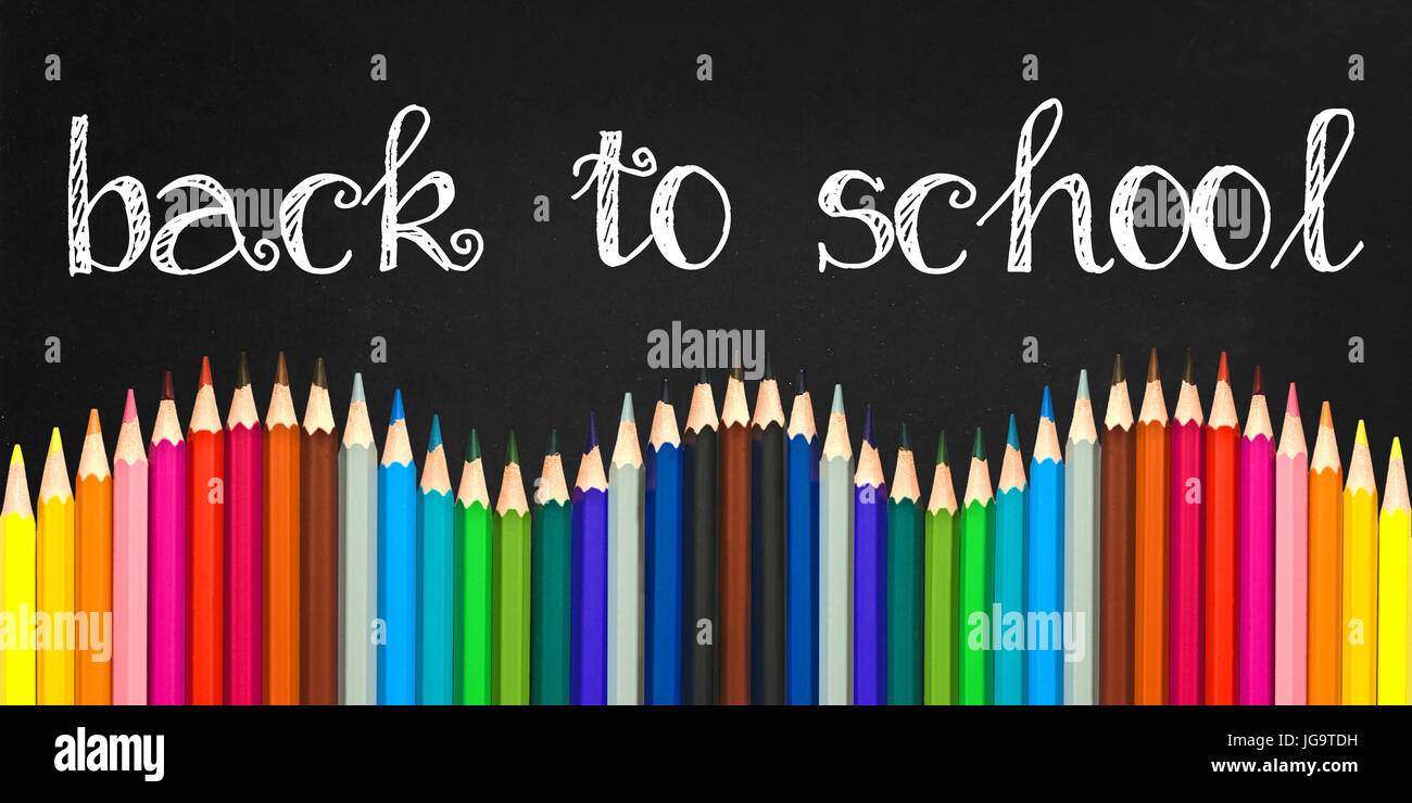 Back to school written on a black board background with a wave of colorful wooden pencils Stock Photo