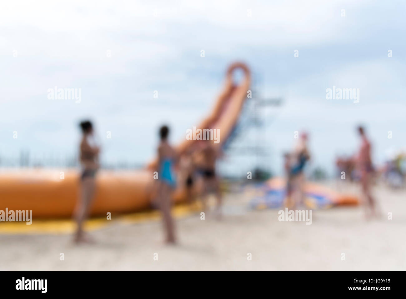 Summer beach with blurry effect, people near inflatable hill, entertainment, abstract background Stock Photo