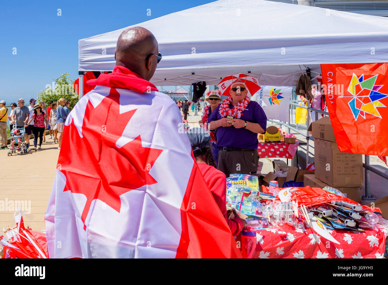 Man wearing Canadian flag, Canada Day, Village of Steveston, Richmond, British Columbia, Canada. Stock Photo