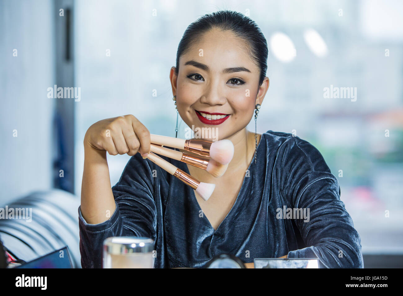 Brunette woman applying make up  closeup portrait of woman with makeup brush near face Stock Photo