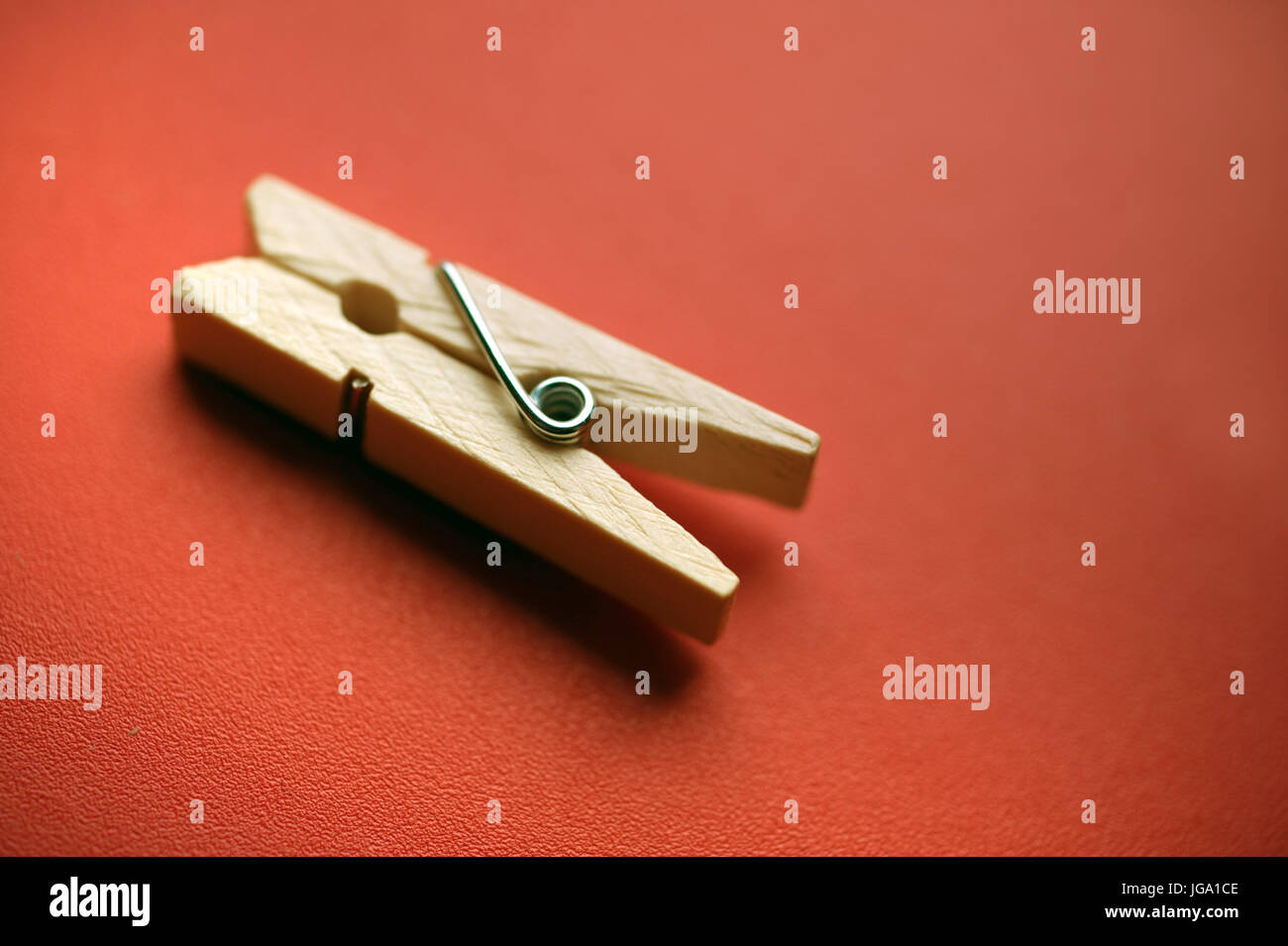 Wooden clothes peg on a red background Stock Photo