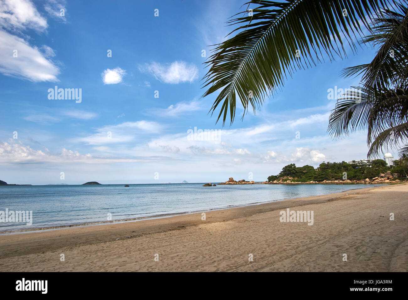 Palm trees with a blue sky with the view to Hong chong at a beach in Nha Trang, Vietnam. Stock Photo