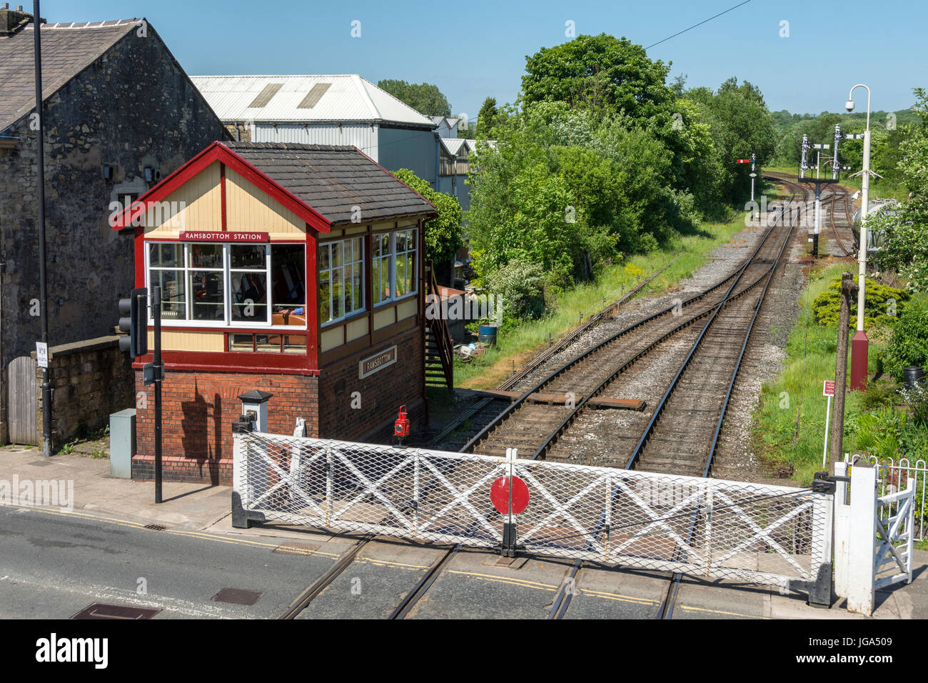 The signal box and level crossing (gates set for road travel), on the East Lancashire Railway at Ramsbottom, Greater Manchester, UK. Stock Photo