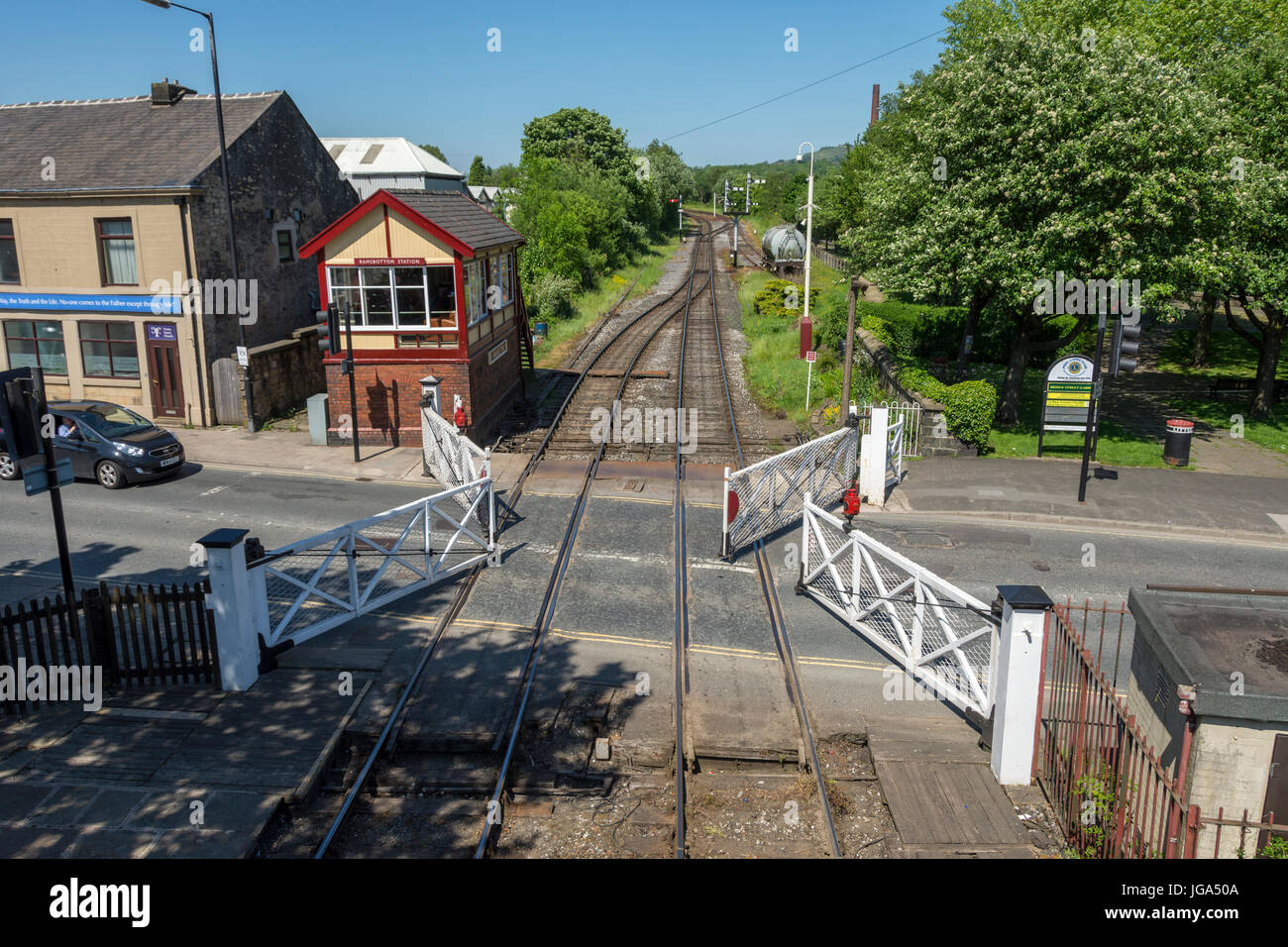 The signal box and level crossing (gates in operation), on the East Lancashire Railway at Ramsbottom, Greater Manchester, UK. Stock Photo