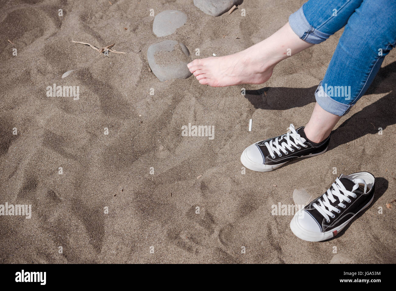 clean beauty white foot lady sit on sandy beach take off one shoes touch  gray stone experience summer feeling wearing blue jeans with copyspace  Stock Photo - Alamy