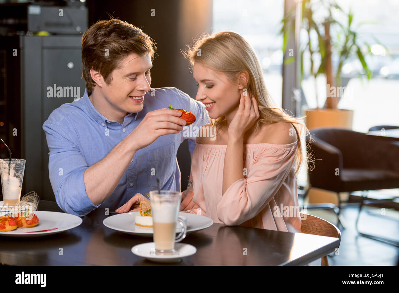 portrait of romantic couple in love having lunch together in restaurant ...