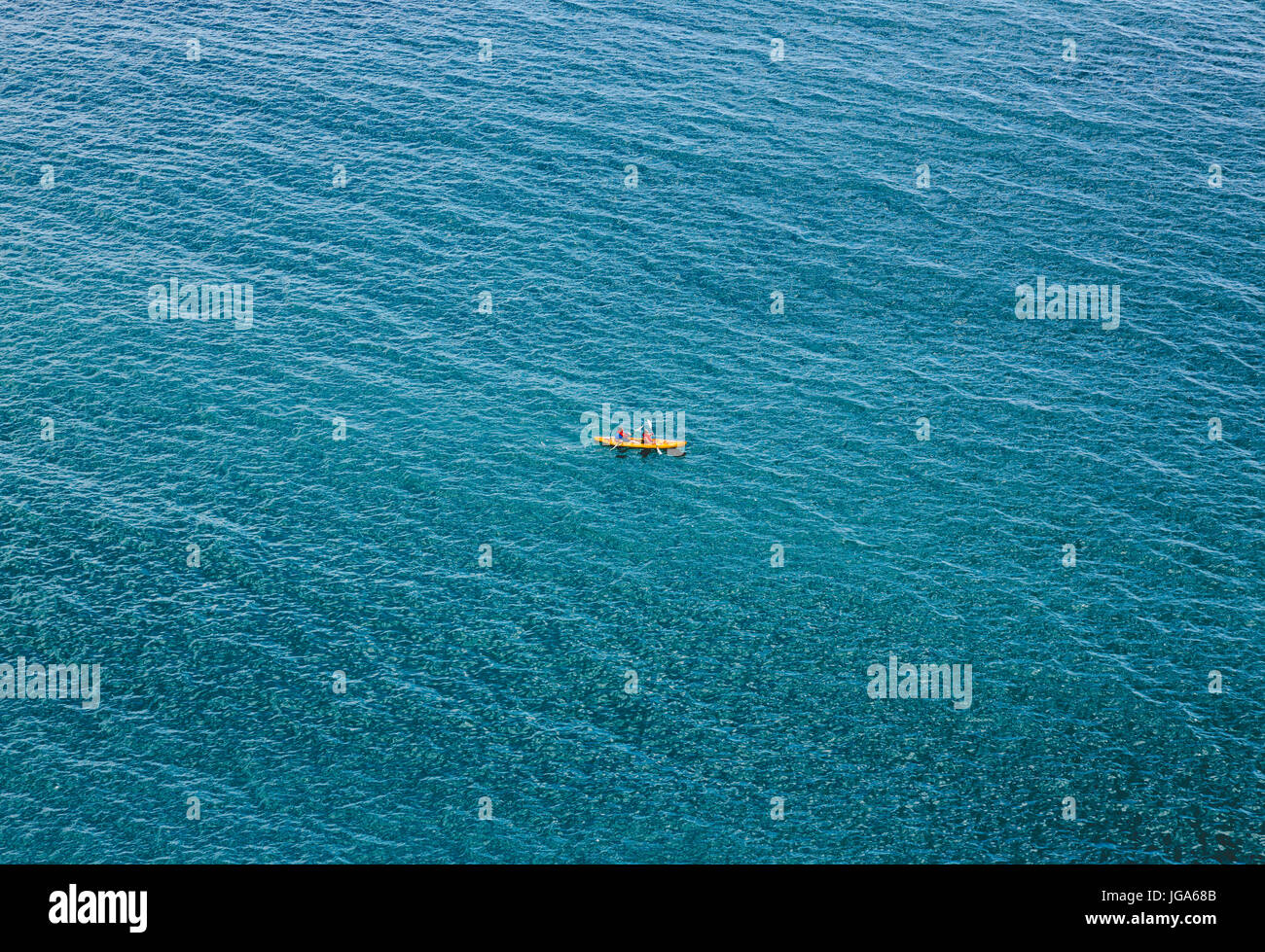 Alone couple in kayak swimm through calm blue sea. Minimalistic crop view from top. Horizontall orientation Stock Photo