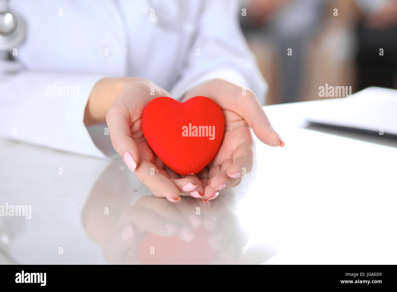 Female doctor with stethoscope holding heart Stock Photo - Alamy