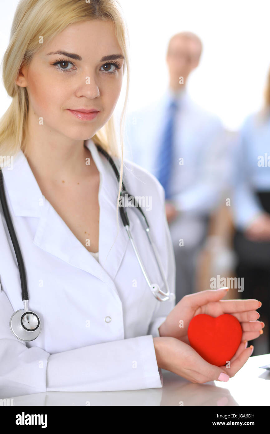 Female doctor with stethoscope holding heart Stock Photo - Alamy