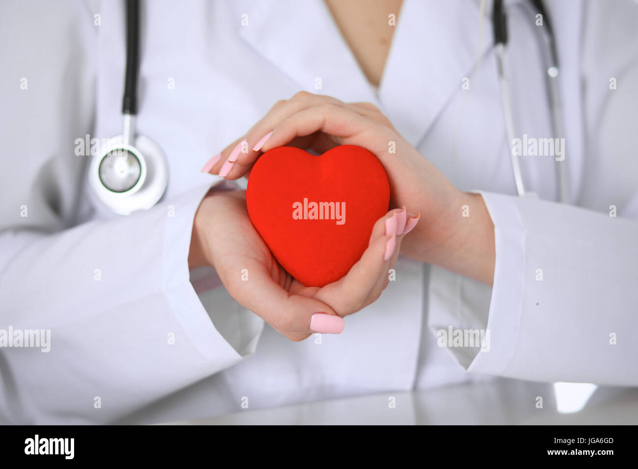 Female doctor with stethoscope holding heart Stock Photo - Alamy
