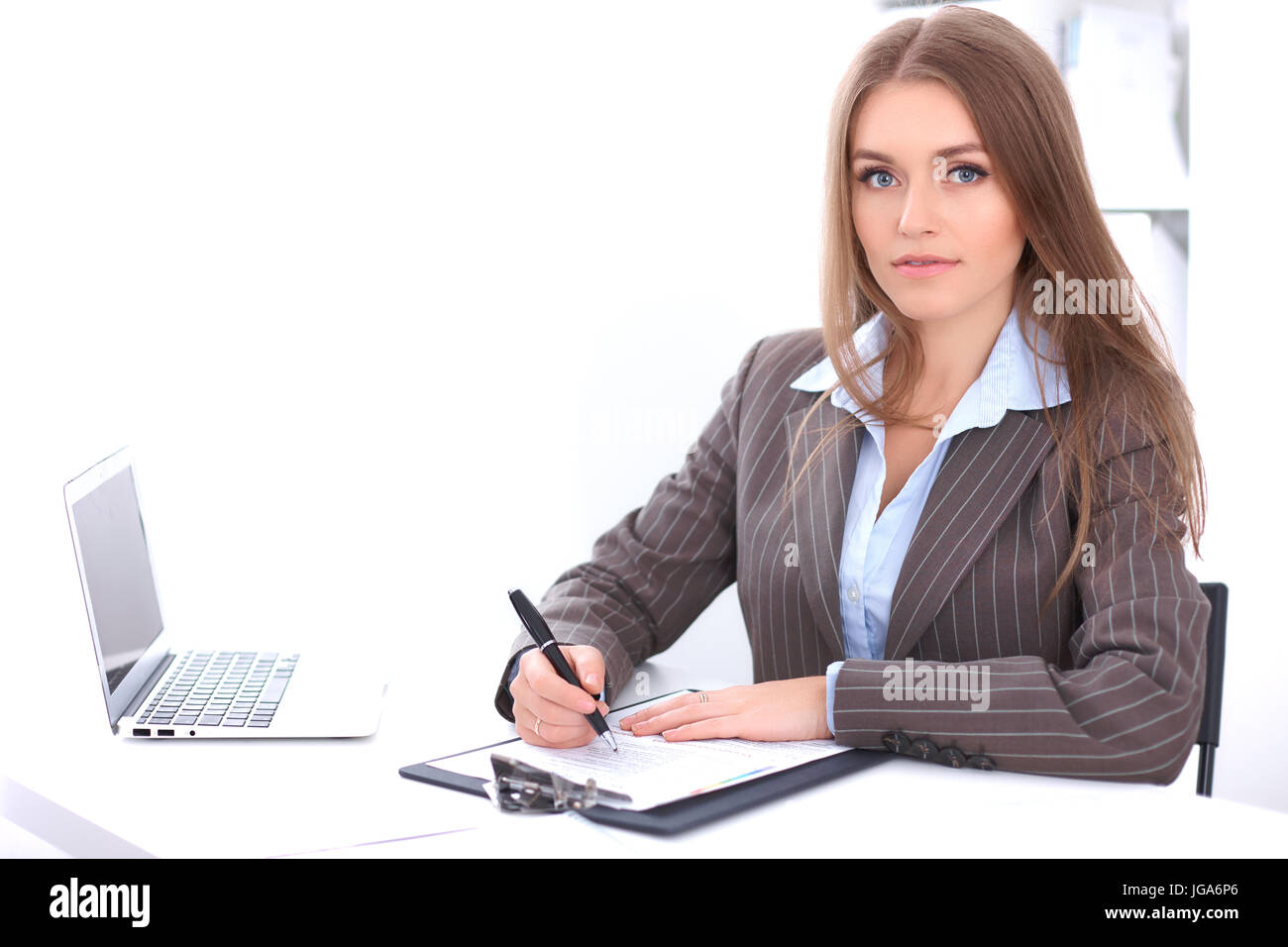 Young business woman sitting at the desk on office background Stock ...