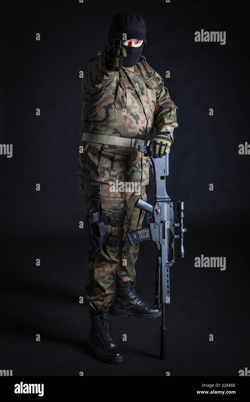 Anti terrorist aiming at camera with a gun on black background Stock Photo