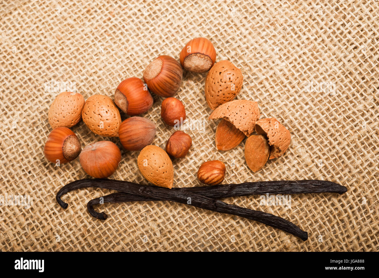 Hazelnuts,almond end vanilla on jute Stock Photo