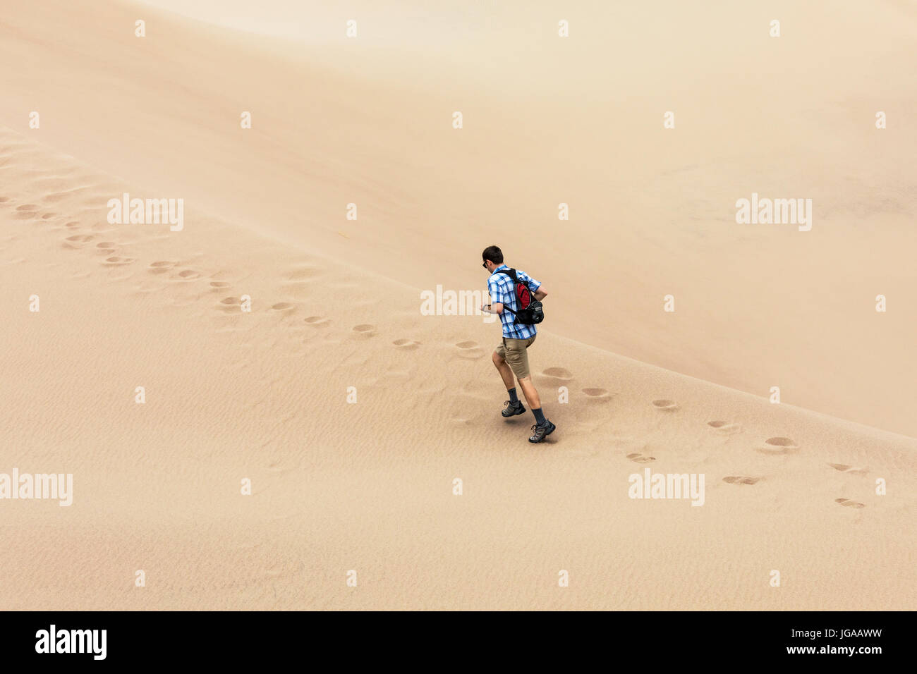 Man jogging & exploring the Great Sand Dunes National Park & Preserve; San Luis Valley; Colorado; USA; 44,246 acres & the preserve an additional 41,68 Stock Photo