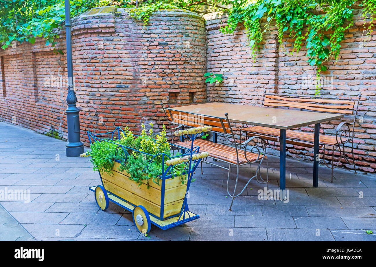 The outdoor cafe in Erekle II street decorated the street with colorful wooden carts with plants and flowers, Tbilisi, Georgia. Stock Photo