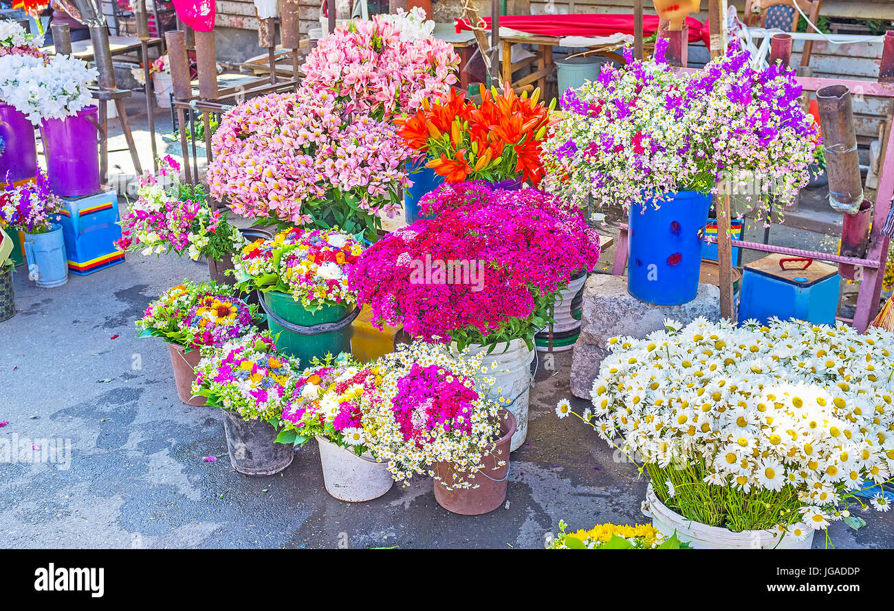 Alstroemeria, carnations, lilies, chamomiles and other flowers in buckets with water on the