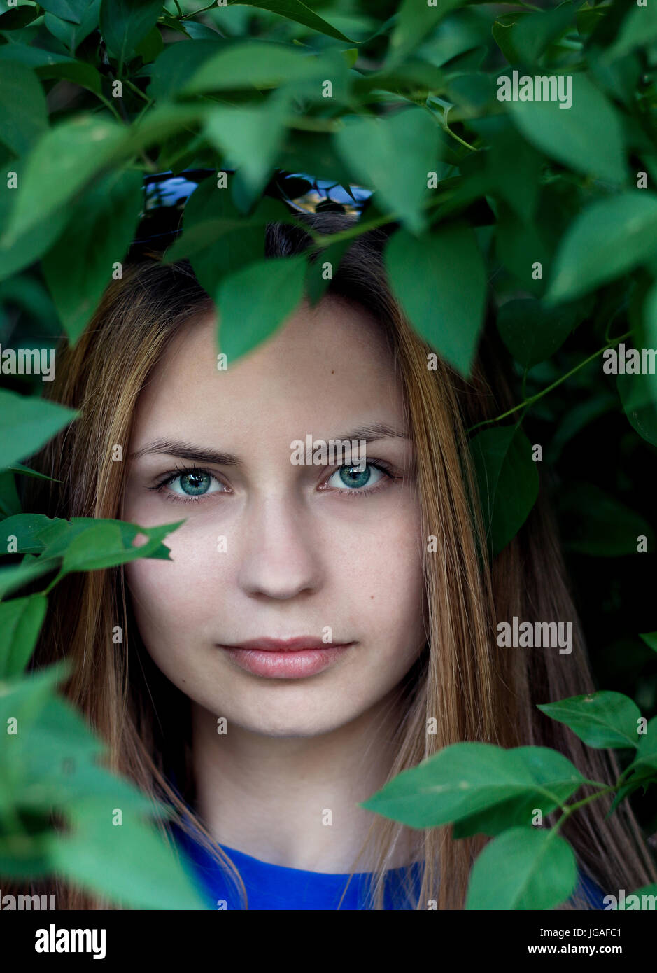 portrait of a cute girl in the green leaves Stock Photo - Alamy