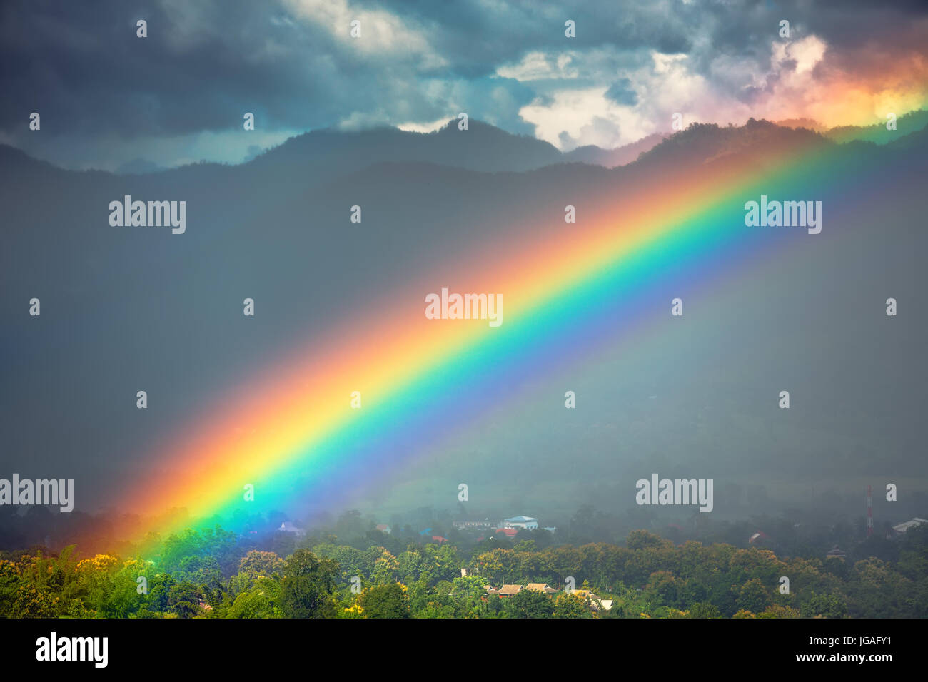Beautiful bright rainbow in the sky after the heavy rain. Stock Photo