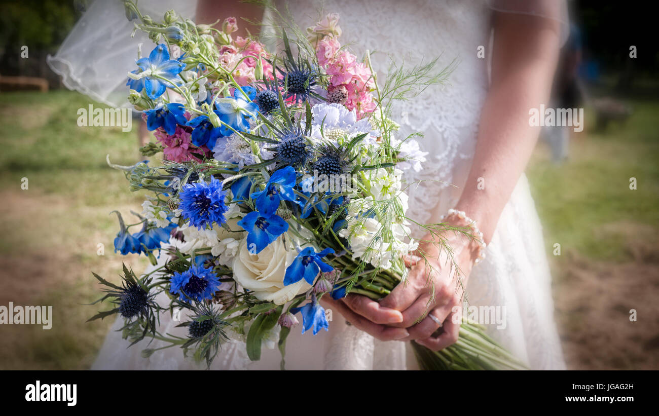 Close up of a bridal bouquet of flowers being held by a bride on her wedding day made of garden flowers with out of focus edges Stock Photo