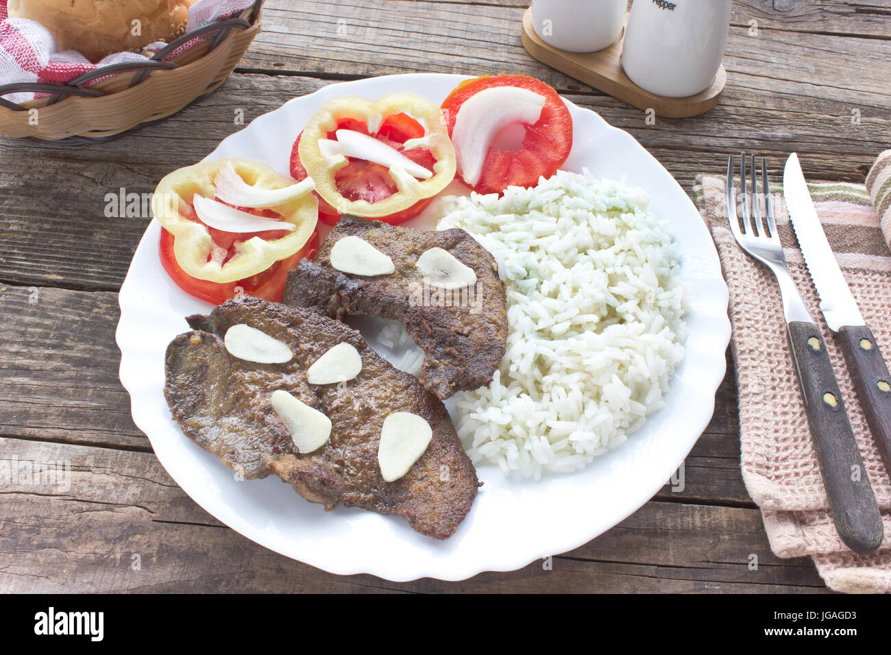 Fried pork liver in plate on wooden table Stock Photo