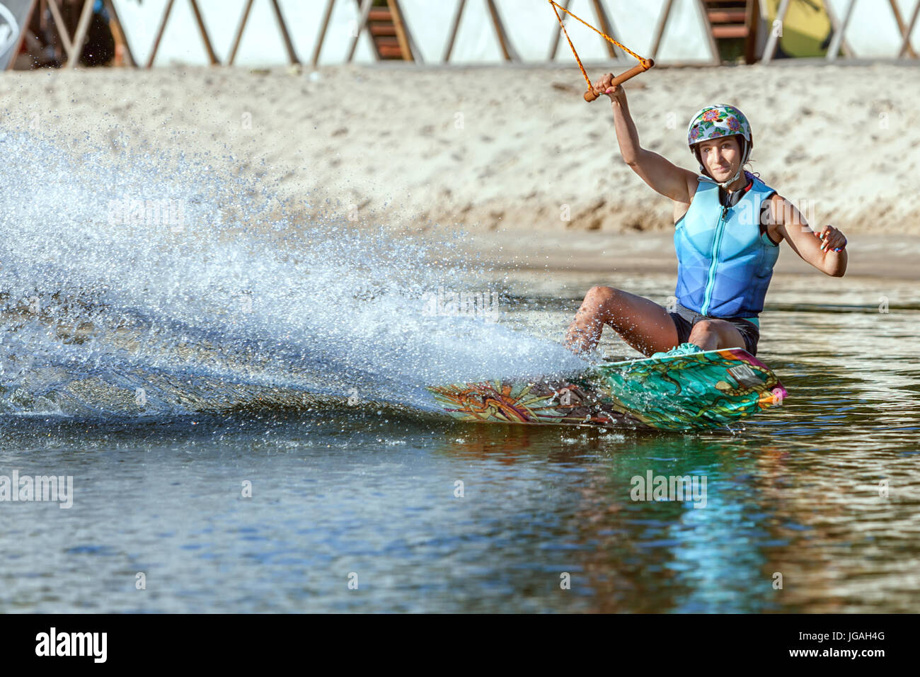 Woman is an extreme sportswoman on a wakeboard on the water. Stock Photo