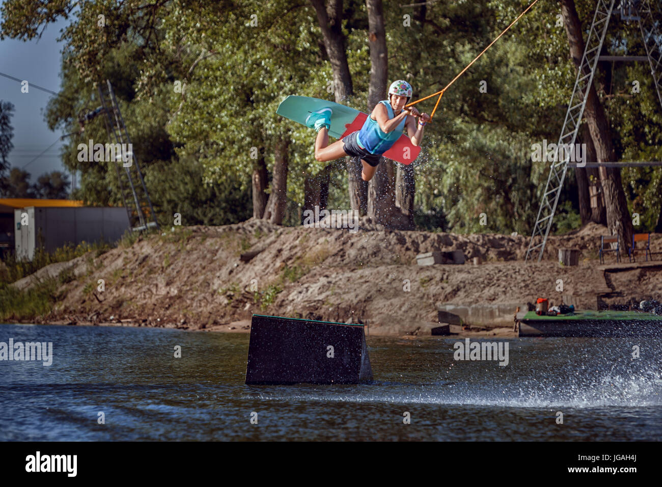 Woman extreme sports on a wakeboard to jump up. Stock Photo