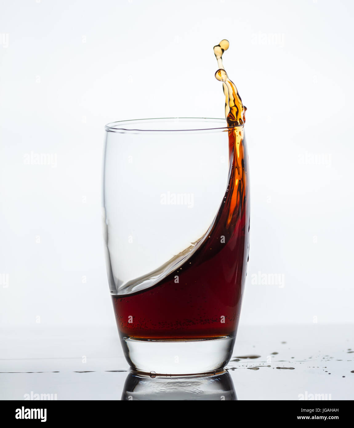 splash of drink from a glass with reflection Stock Photo Alamy