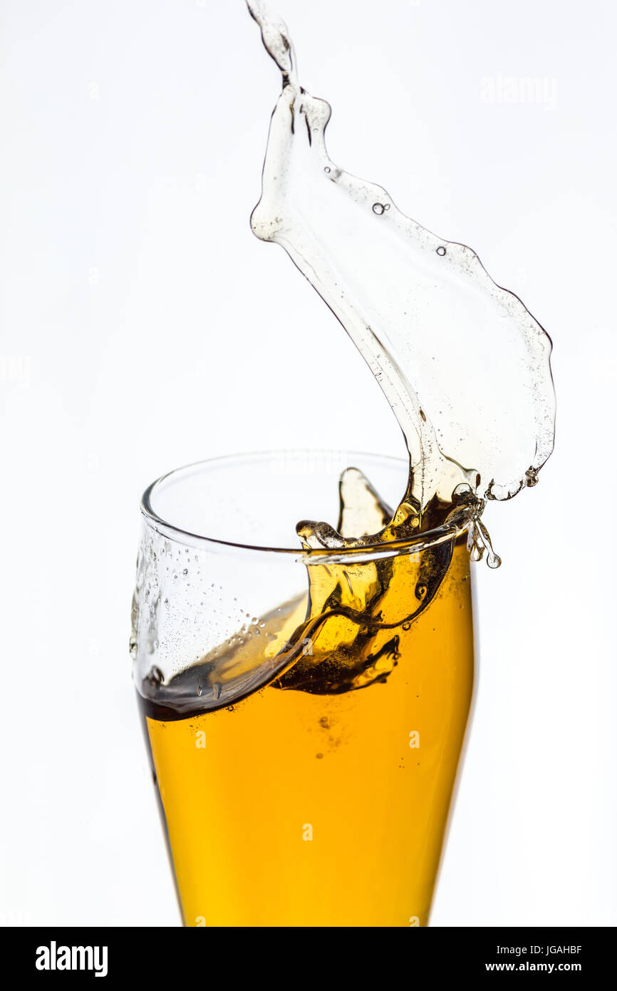 Splashing beer from a glass on white background Stock Photo Alamy