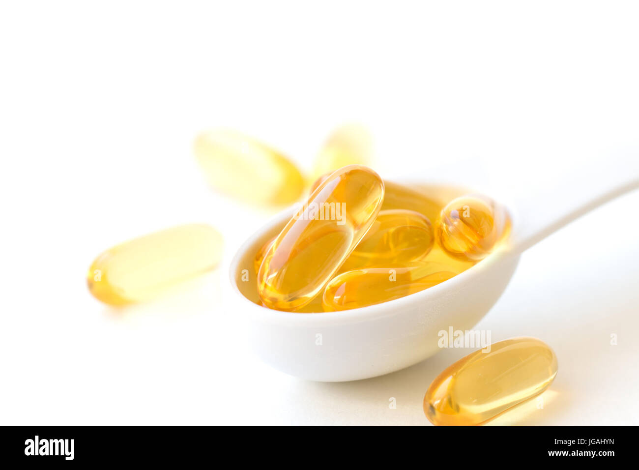 Fish oil capsules in a spoons on white background. Stock Photo