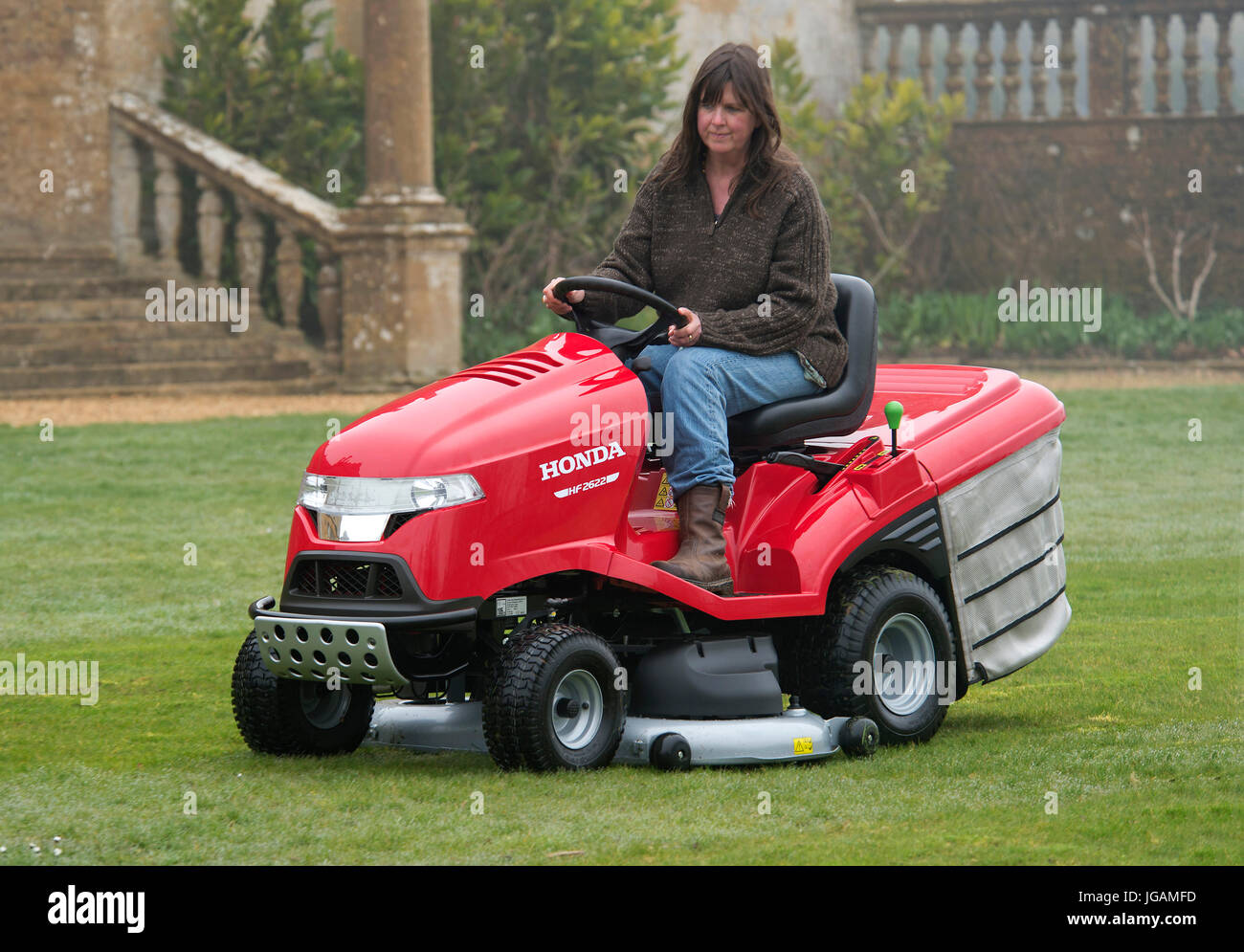 Sit-on mowers being used to cut grass Stock Photo