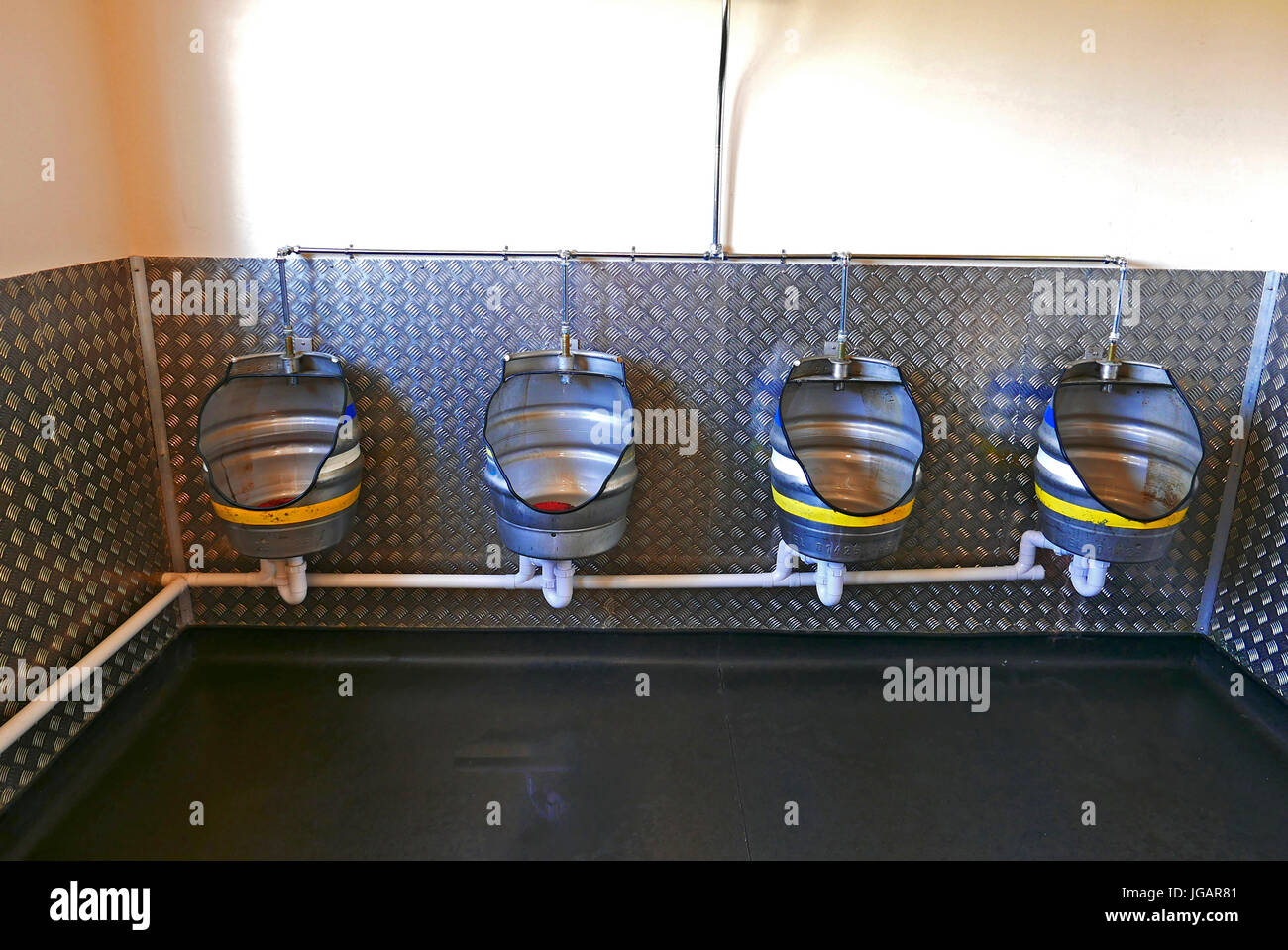 Gents urinals made from old recycled beer barrels Stock Photo