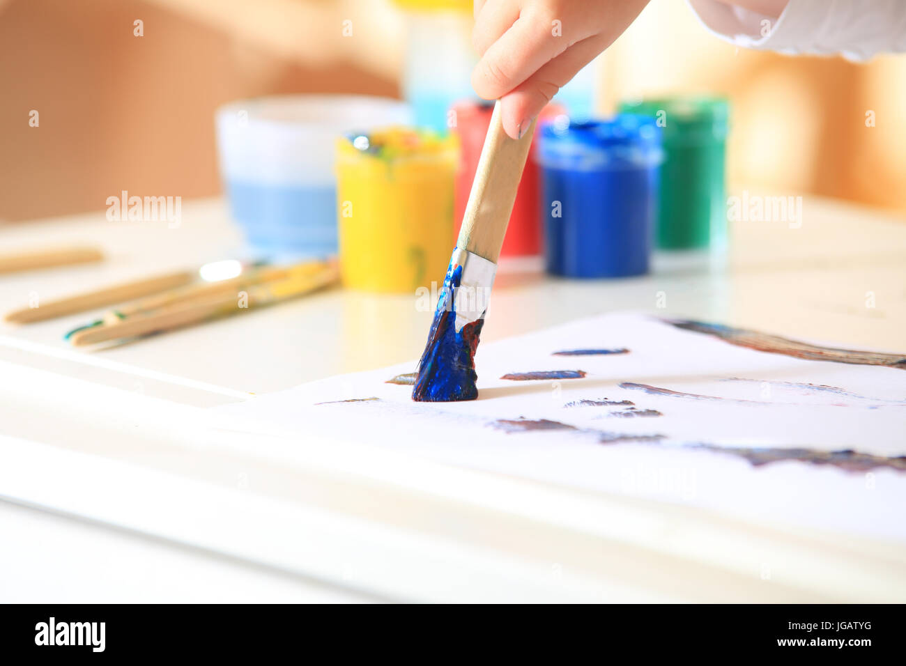 https://c8.alamy.com/comp/JGATYG/brush-in-blue-paint-on-colorful-paint-box-background-childrens-creativity-JGATYG.jpg