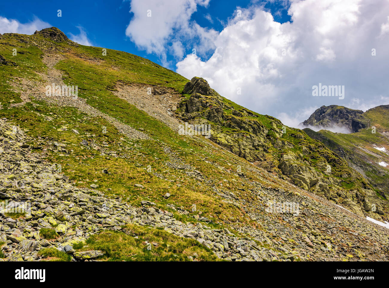 edge of steep slope on rocky hillside in cloudy weather. dramatic scenery in mountains Stock Photo