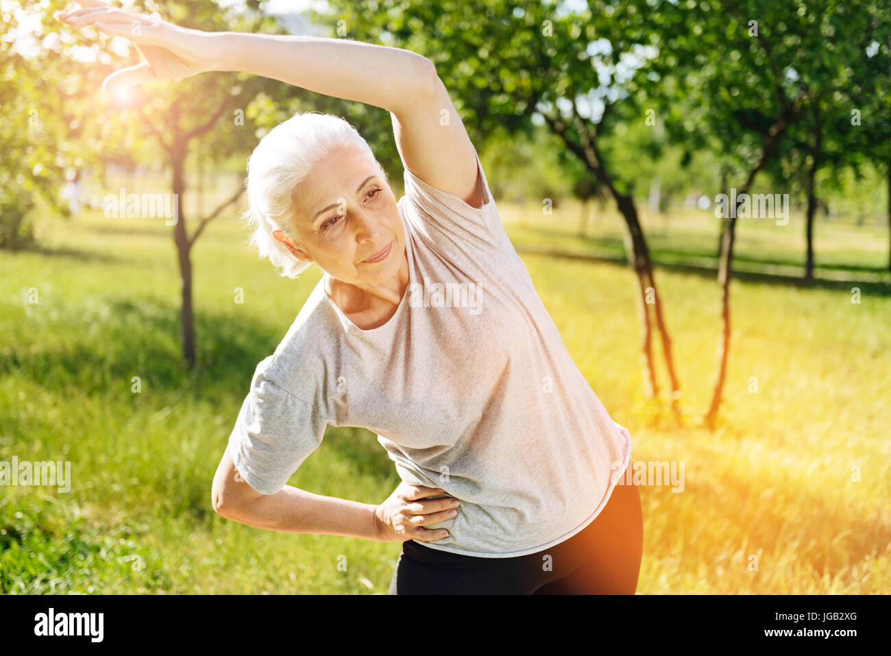 Pleasant aged woman doing sport exercises Stock Photo