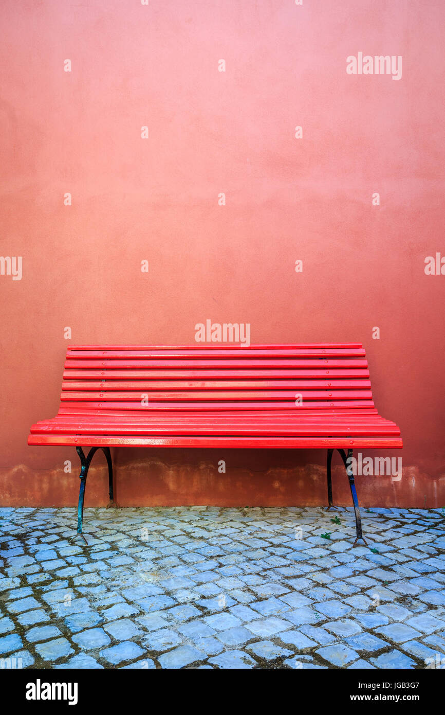 Minimalistic red bench and red wall . Stock Photo