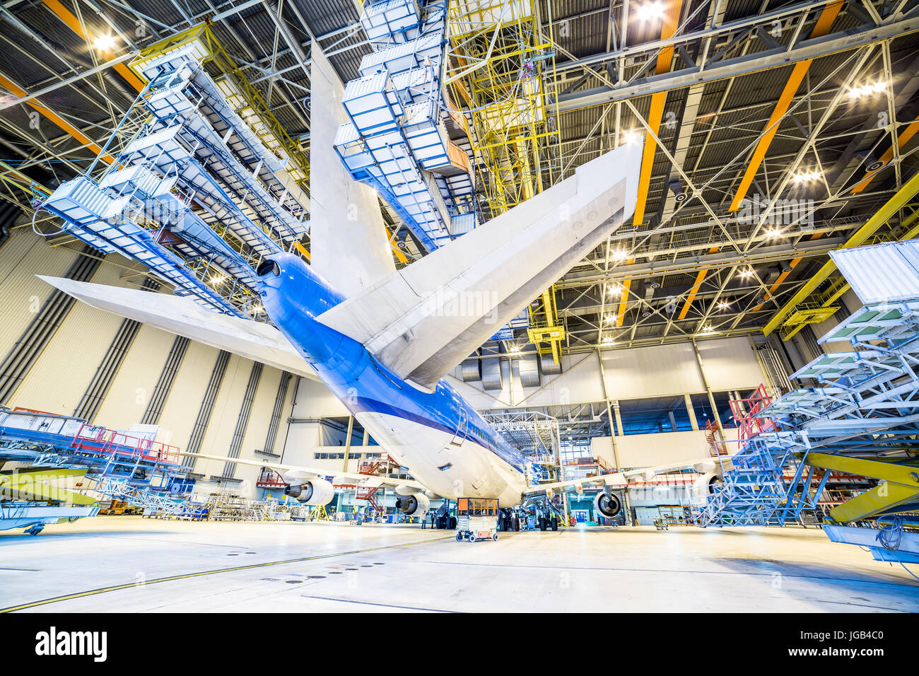 Refurbishment of white and blue airplane in a hangar. Stock Photo